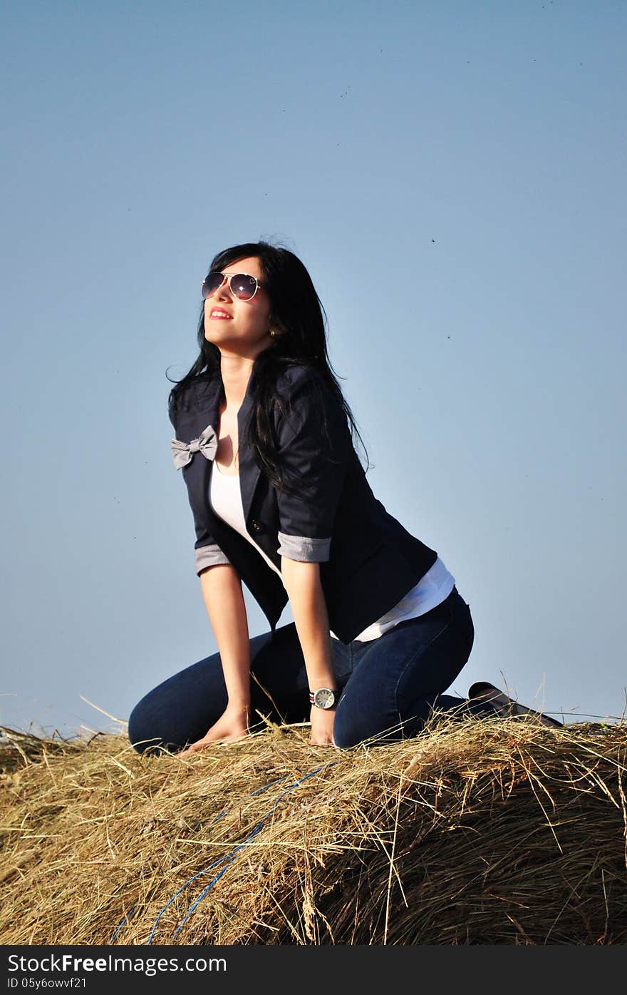 Beautiful girl sit on haystacks