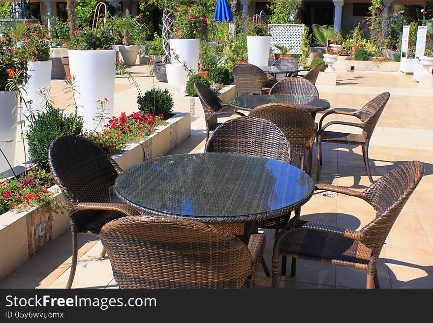 Modern outdoors bar area on the wooden deck of a resort patio surrounded by decorative flowers. Modern outdoors bar area on the wooden deck of a resort patio surrounded by decorative flowers