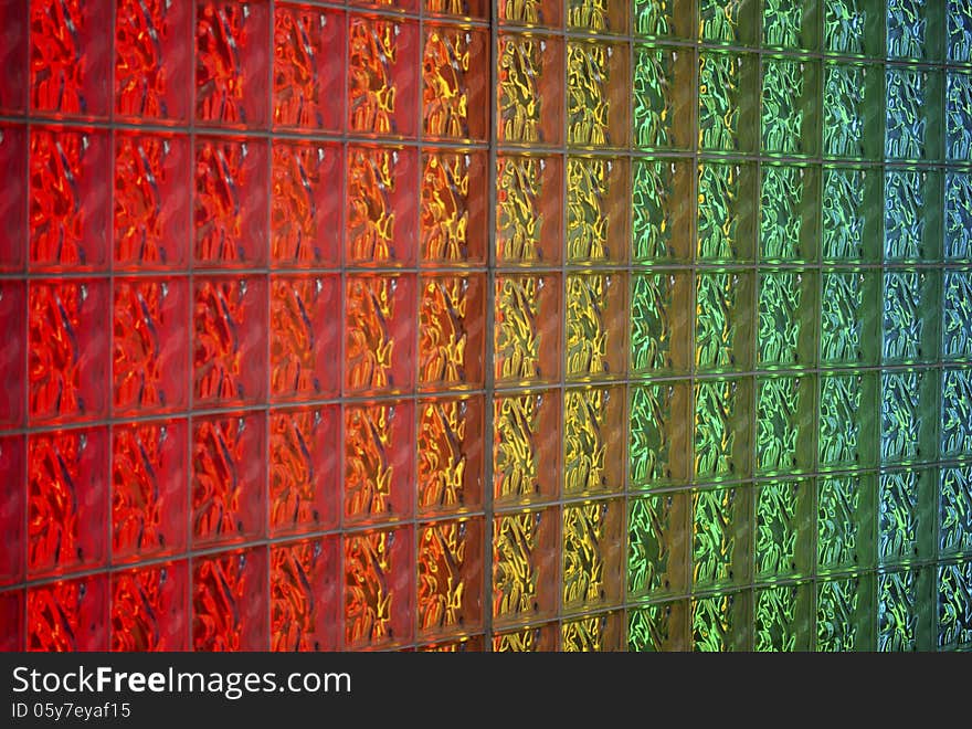 Detail of glass block wall back-lit with neon lights in rainbow colors. Image shows detail of blocks and colors. Detail of glass block wall back-lit with neon lights in rainbow colors. Image shows detail of blocks and colors.