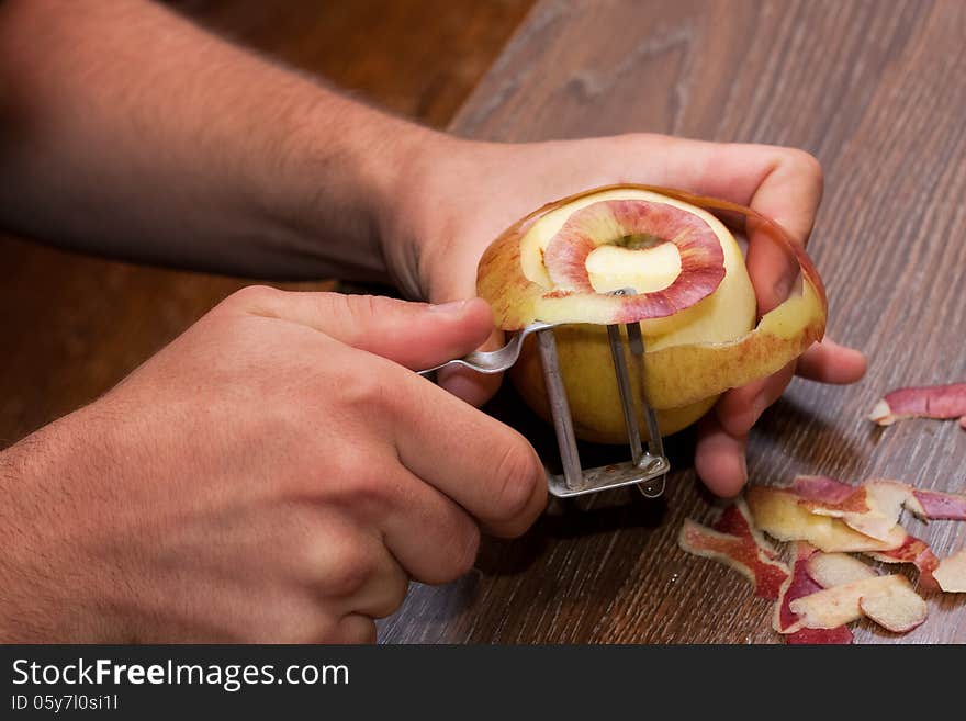 One hands peel an apple with a tool