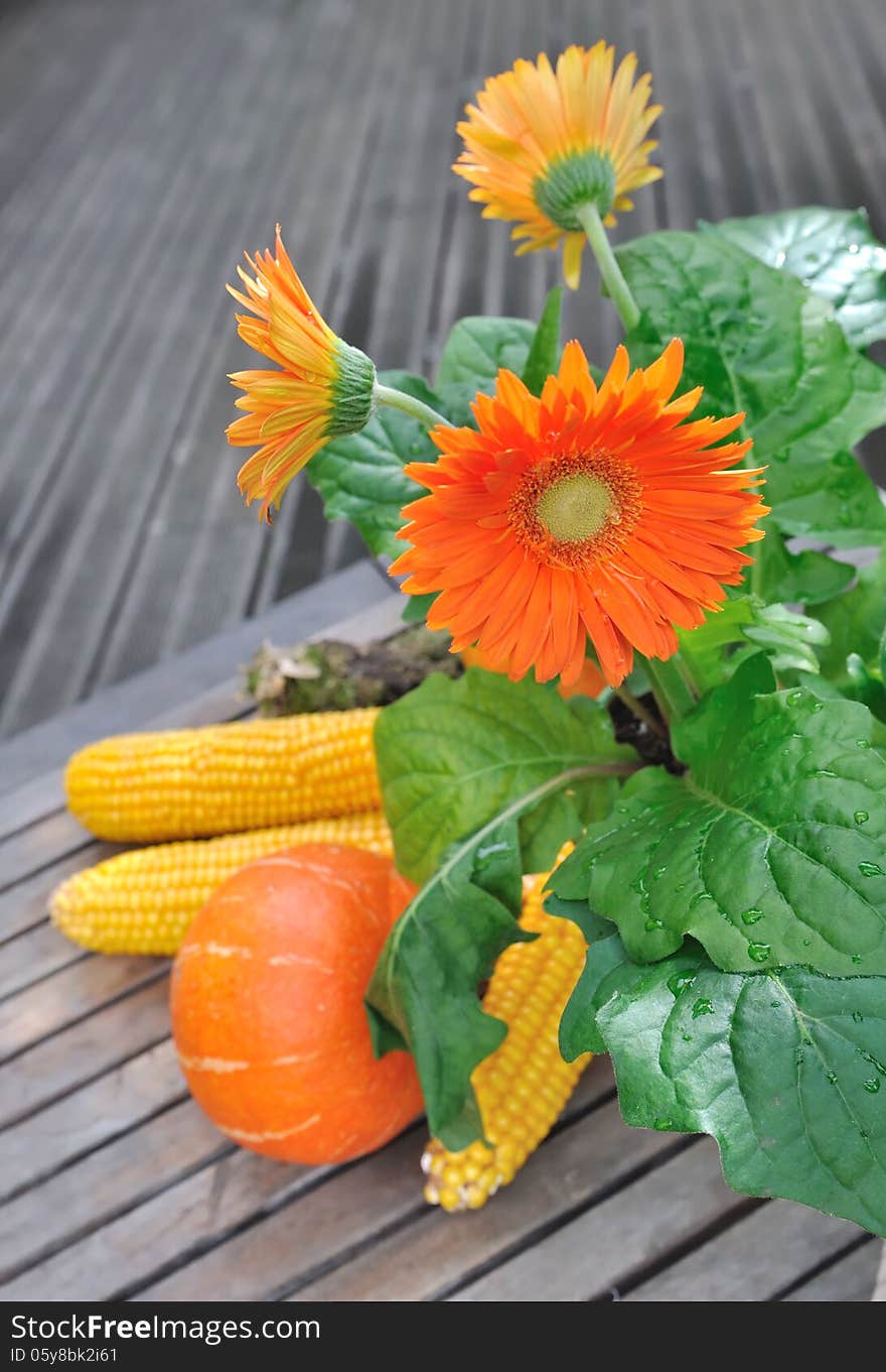 Pot of colorful flowers and vegetables in a wooden terrace