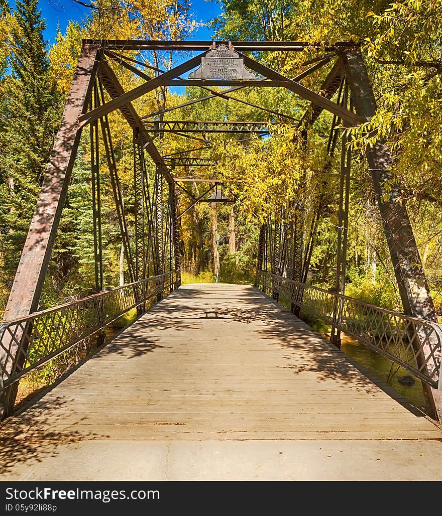 Old bridge surrounded by autumn trees in Colorado