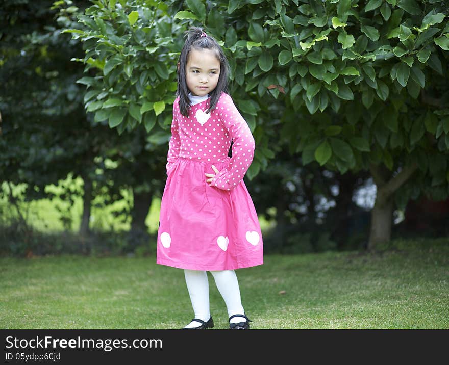 Enigmatic asian girl child in the garden. Enigmatic asian girl child in the garden.