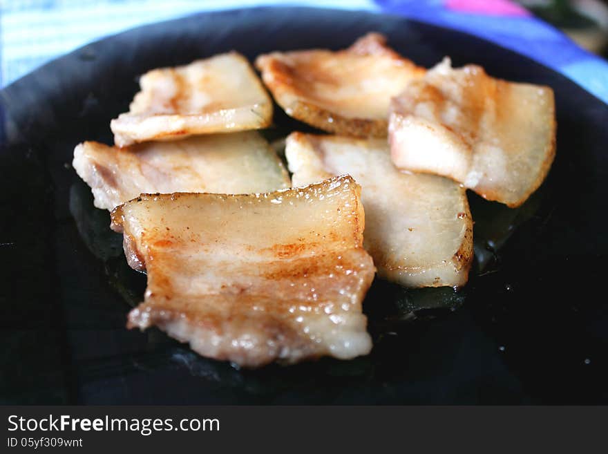 Tasty fried pieces of lard on the plate