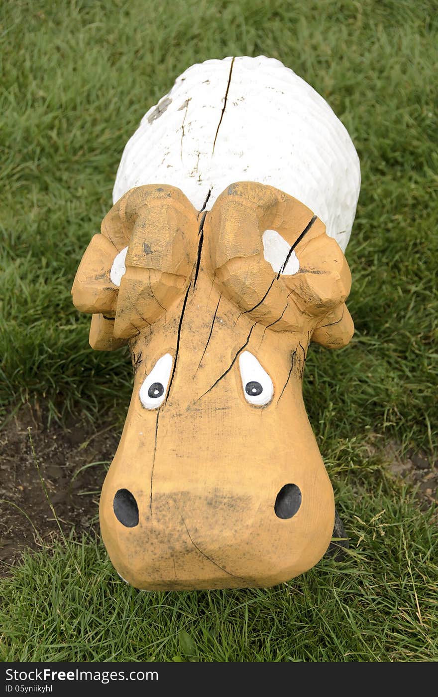 Sheep of wood, on a grass in a park playground.