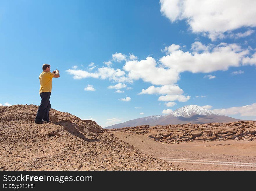 Man taking pictures of snowy mountain at Bolivian altiplano. Man taking pictures of snowy mountain at Bolivian altiplano