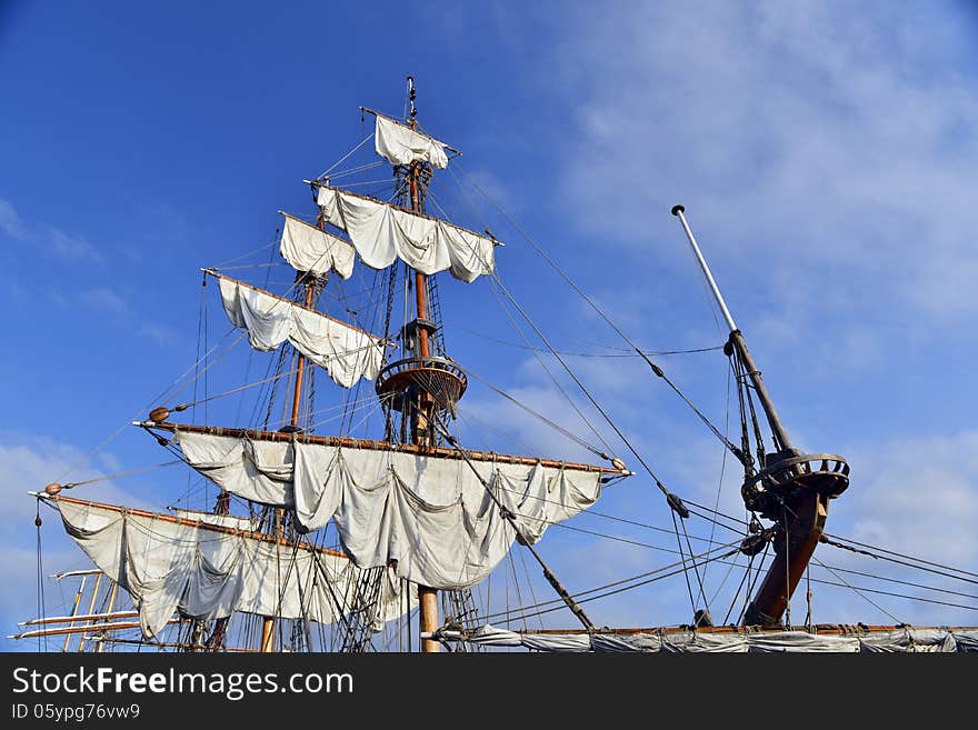 Yacht mast with sails against the sky