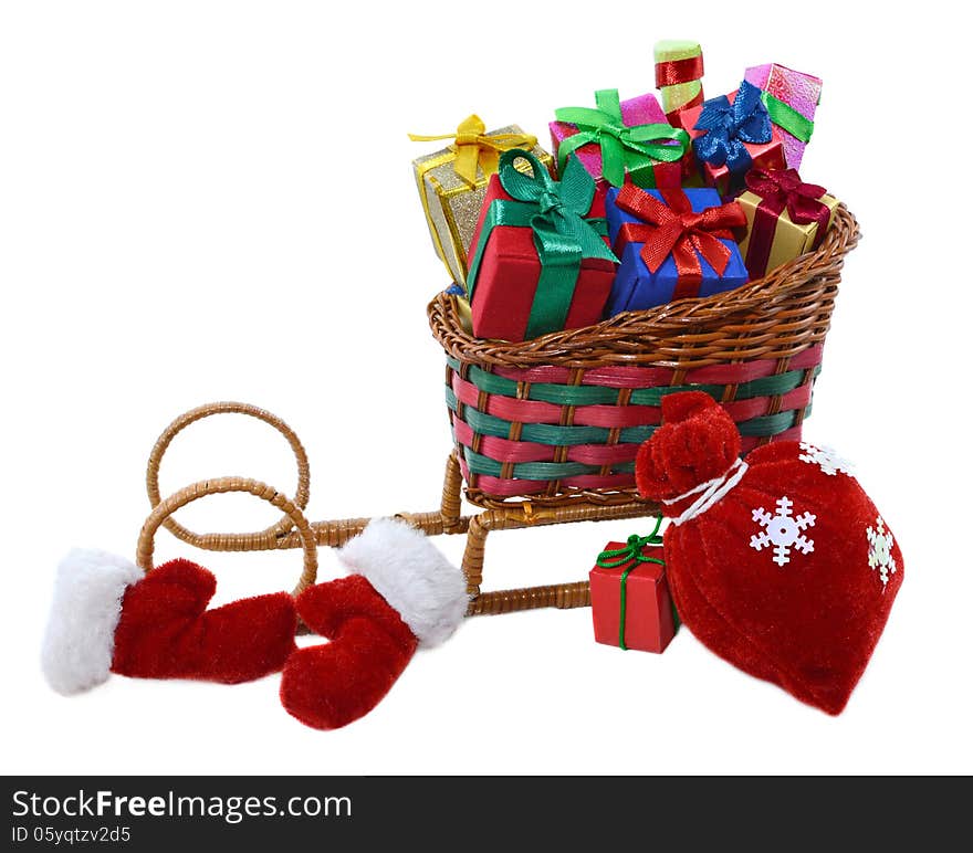 Toy Santas sledges with colorful gifts, red bag and furry mittens isolated. Toy Santas sledges with colorful gifts, red bag and furry mittens isolated