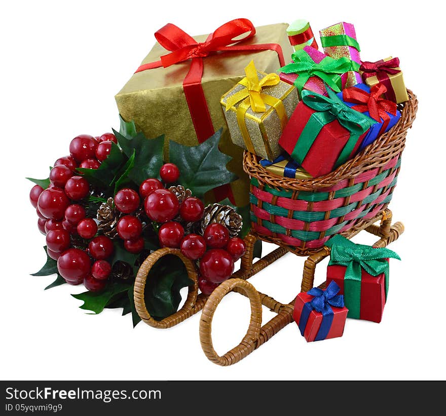 Toy Santas sledges with colorful gift boxes and bunch of berries isolated. Toy Santas sledges with colorful gift boxes and bunch of berries isolated