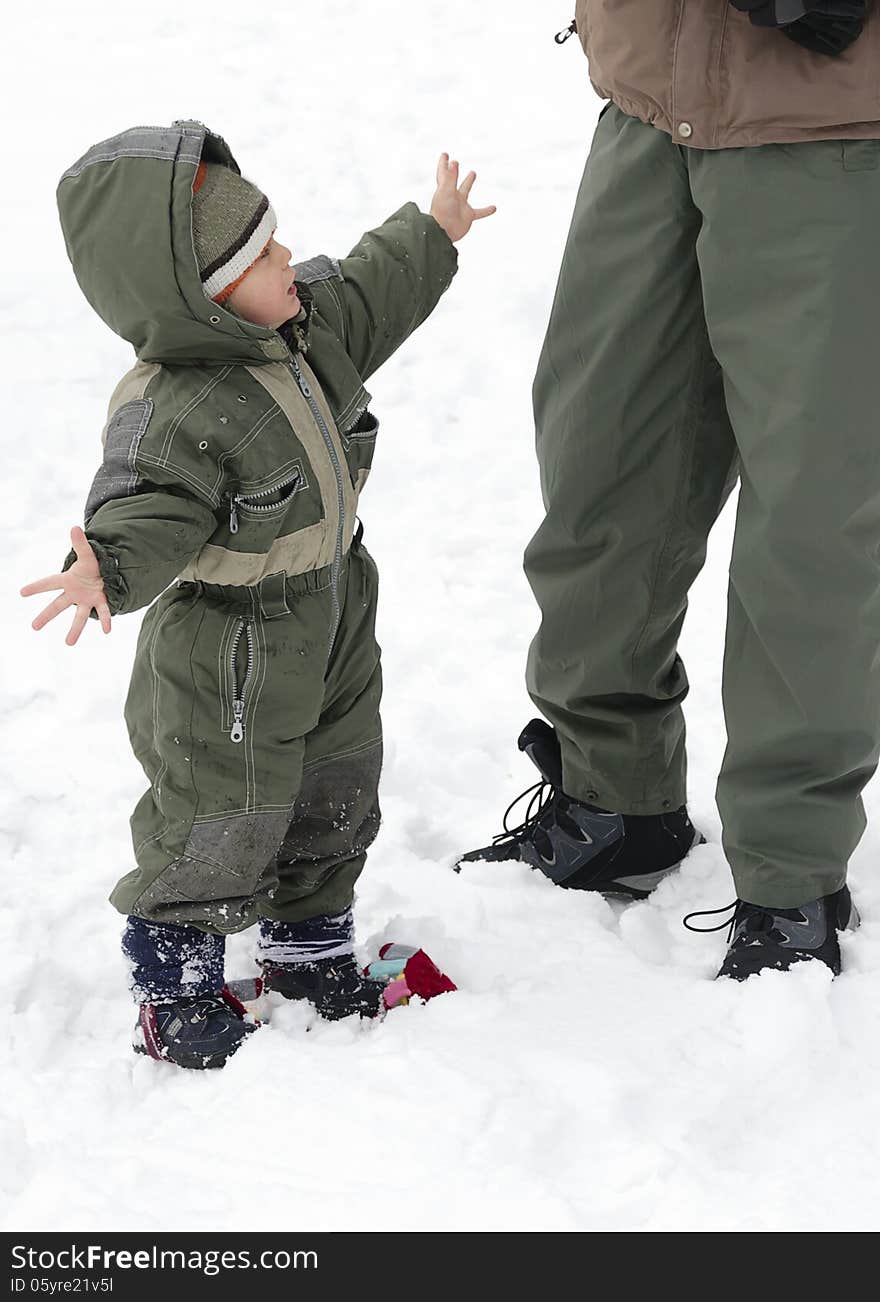 Child in winter snow with parent