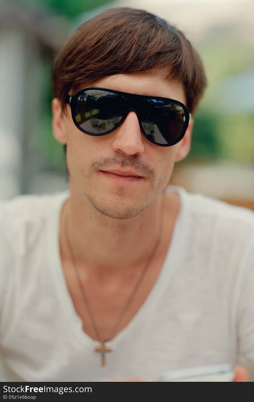 Portrait of a Man in sunglasses and a white t-shirt