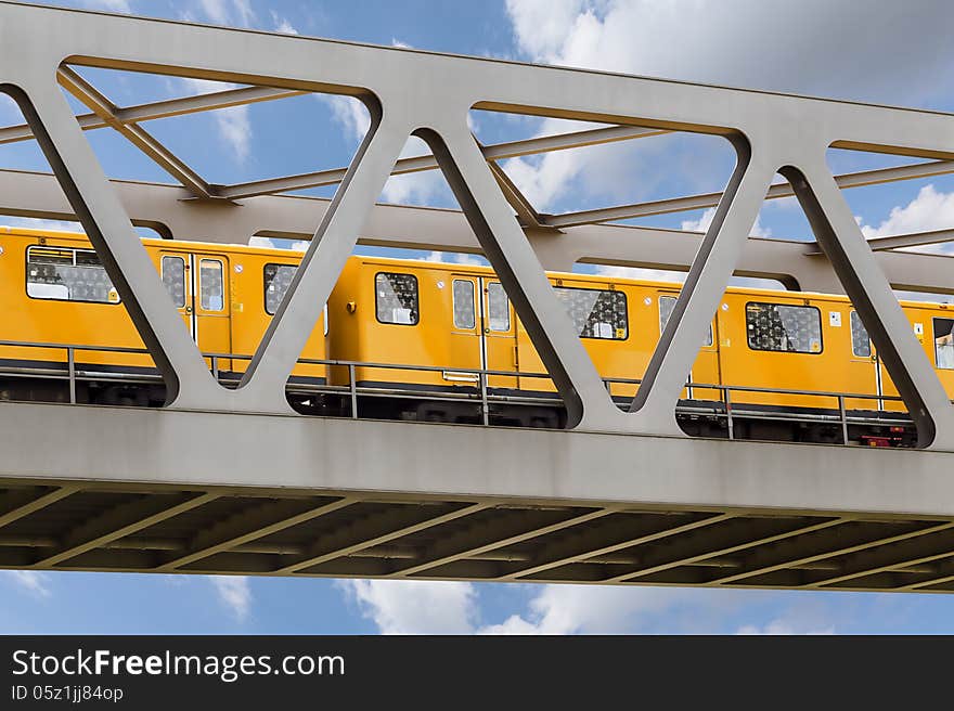 Yellow Moving Train On An Iron Bridge With Blue Sky