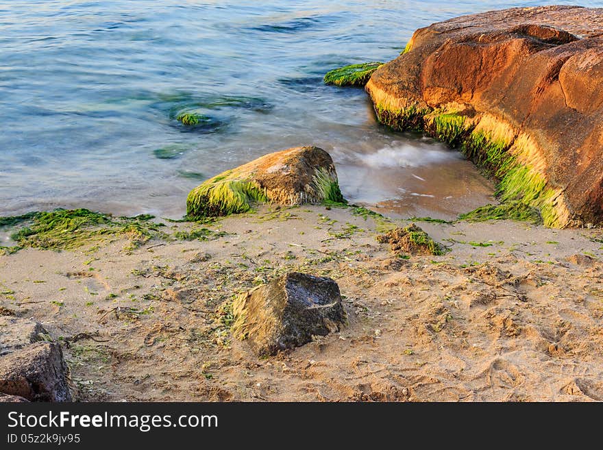 Sea wave strugle with stone on the sandy beach