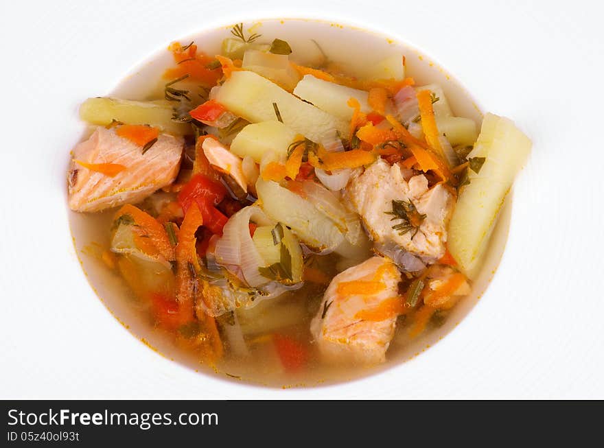 Delicious Fish Soup with Salmon, Potato, Leek, Carrot and Greens in White Soup Plate closeup