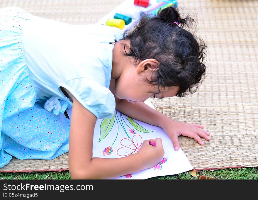 Going back to school :.Colse up girl drawing and painting over green grass background. Going back to school :.Colse up girl drawing and painting over green grass background