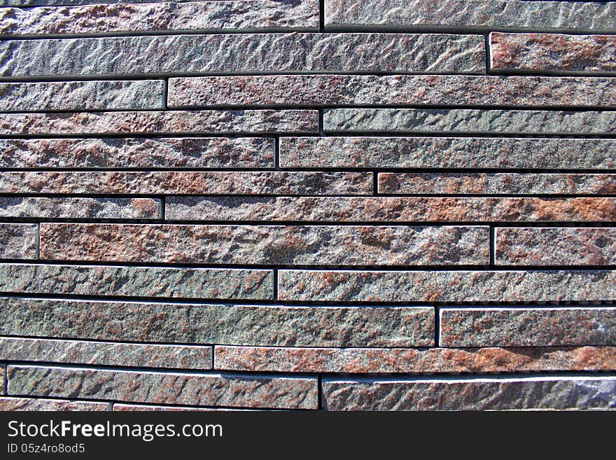 Stone wall cladding, pattern by modern wall of bricks sunlight.