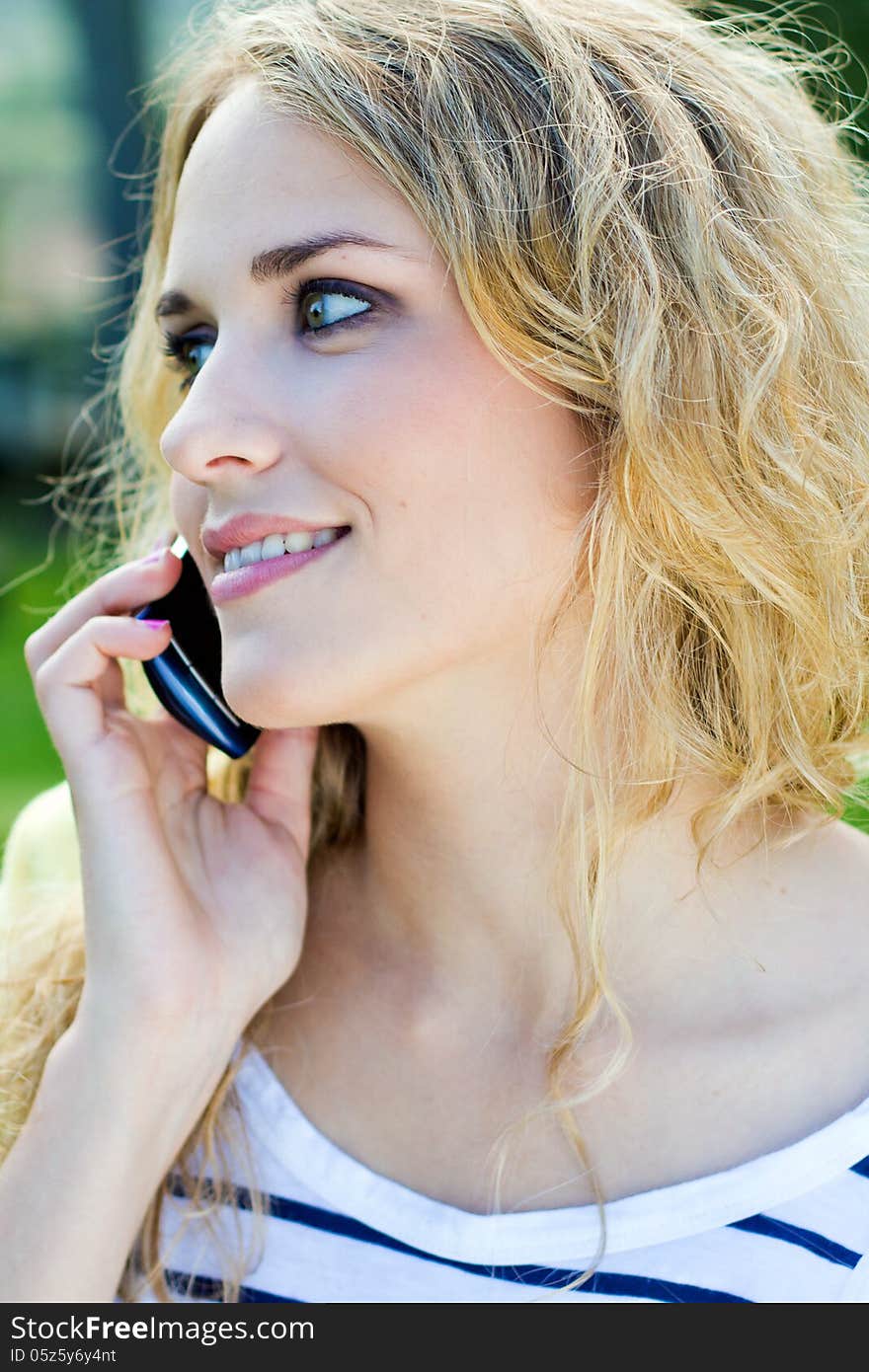 Young Blonde Girl Whit Smartphone At The Park