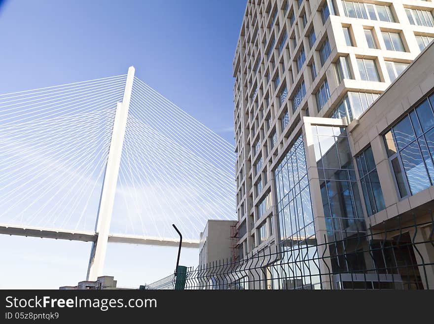 Big suspension bridge in beams of the coming sun against the blue sky