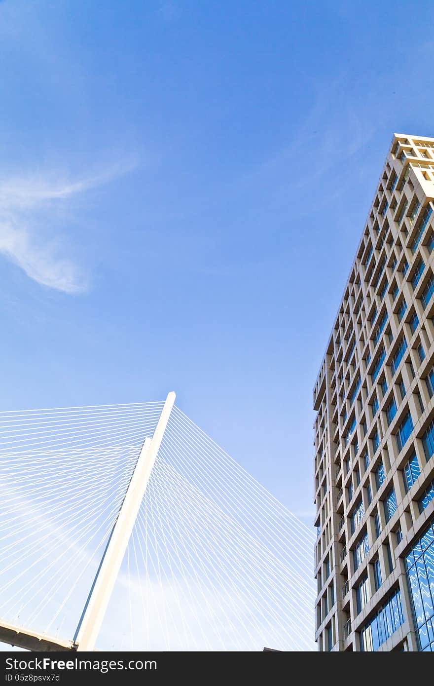 Big suspension bridge in beams of the coming sun against the blue sky