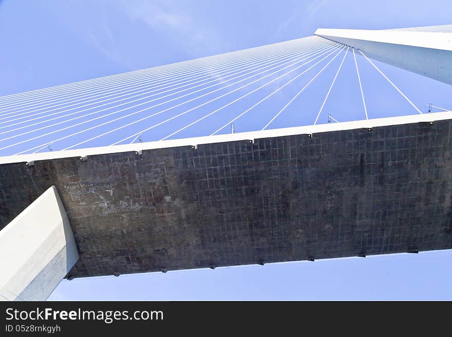 Big suspension bridge in beams of the coming sun against the blue sky