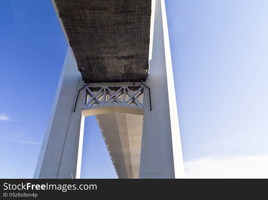 Big suspension bridge in beams of the coming sun against the blue sky