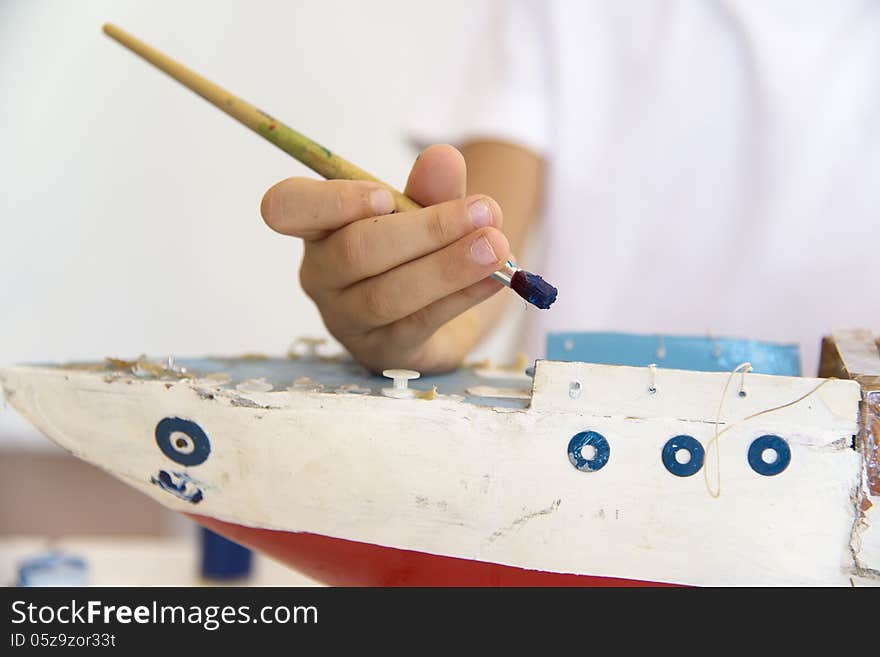 Boy Painting Old Wooden Ship