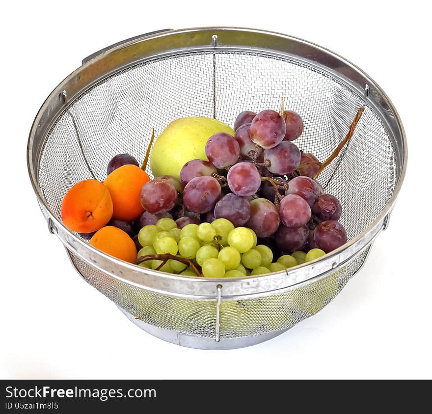 Summer fruits of grapes, apricots and apples in a strainer. Summer fruits of grapes, apricots and apples in a strainer