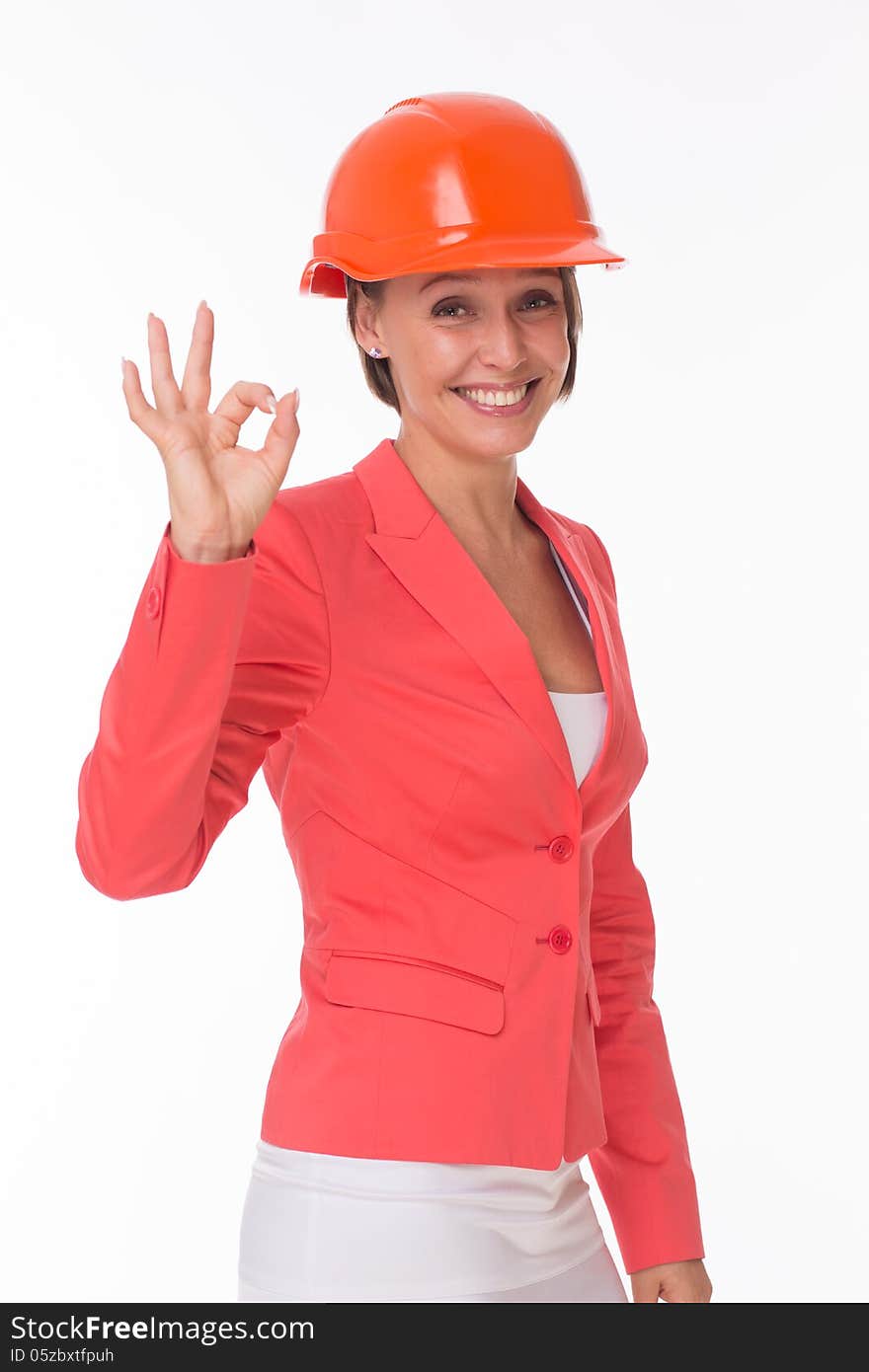 Business woman in helmet and jacket show Okay isolated on white