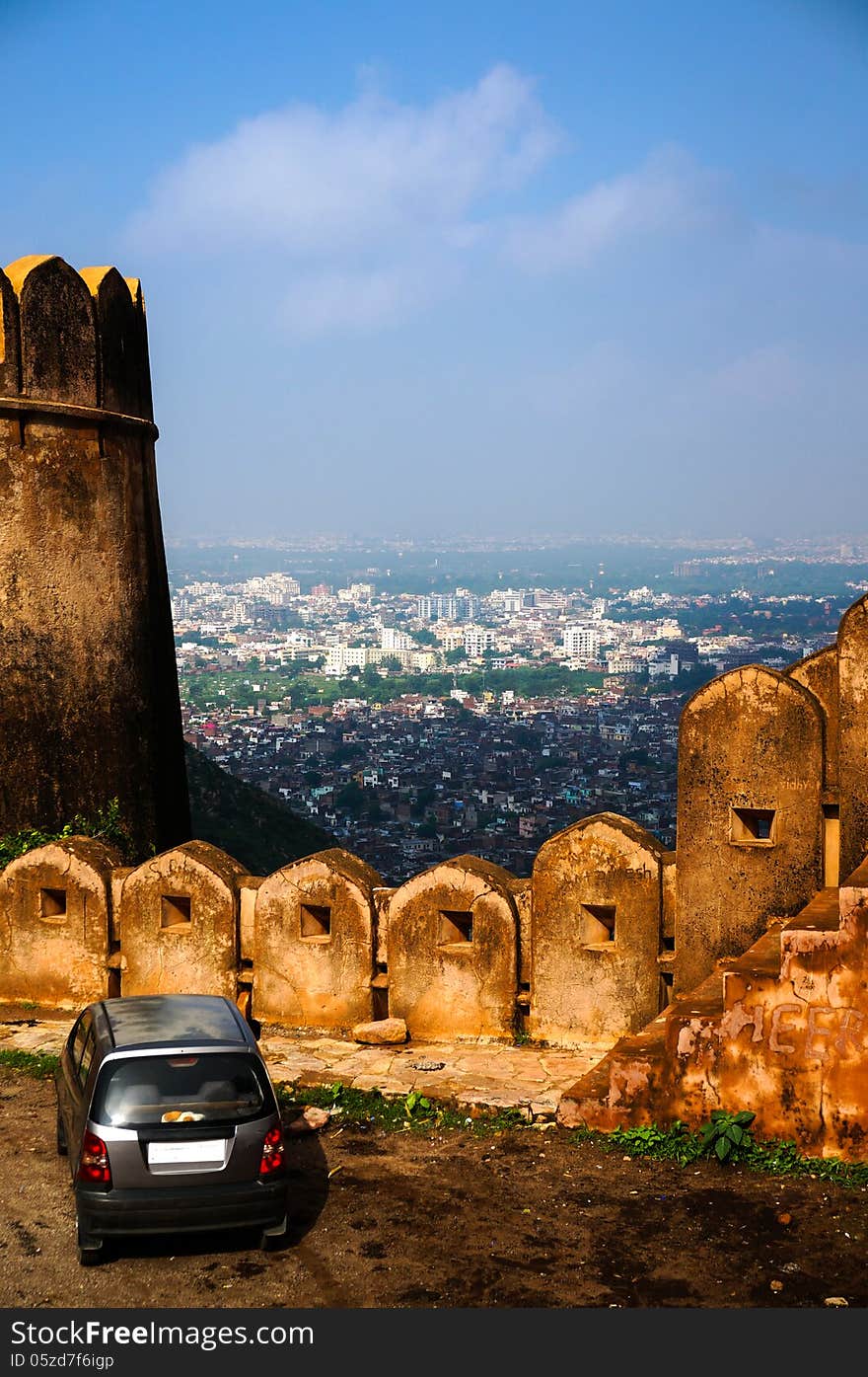 Car standing near fort wall looking down at city