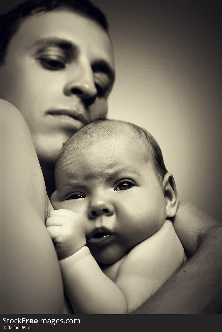 Father Holding His Newborn Baby In His Arms