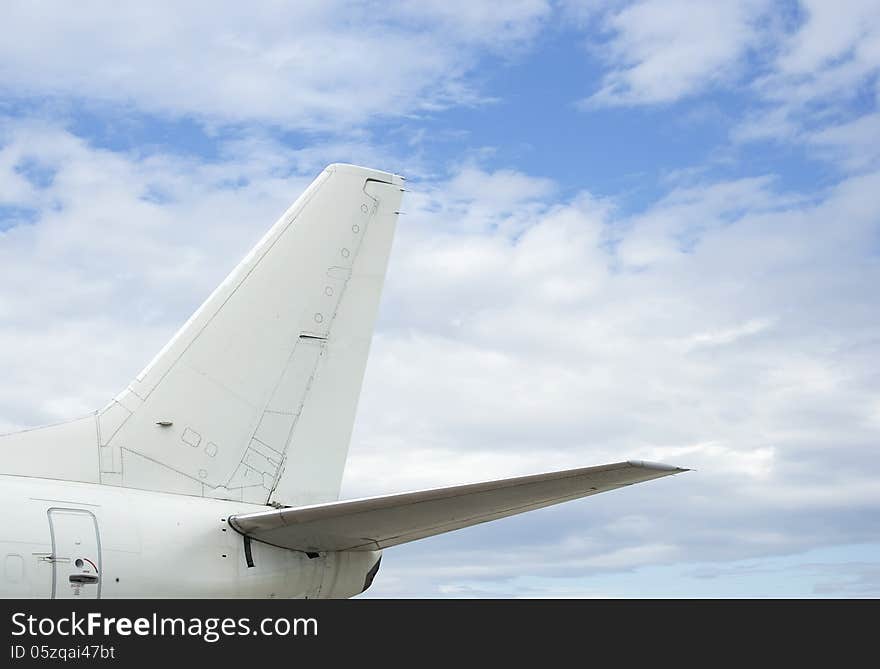 Crop of the airplane back wing on the sky background