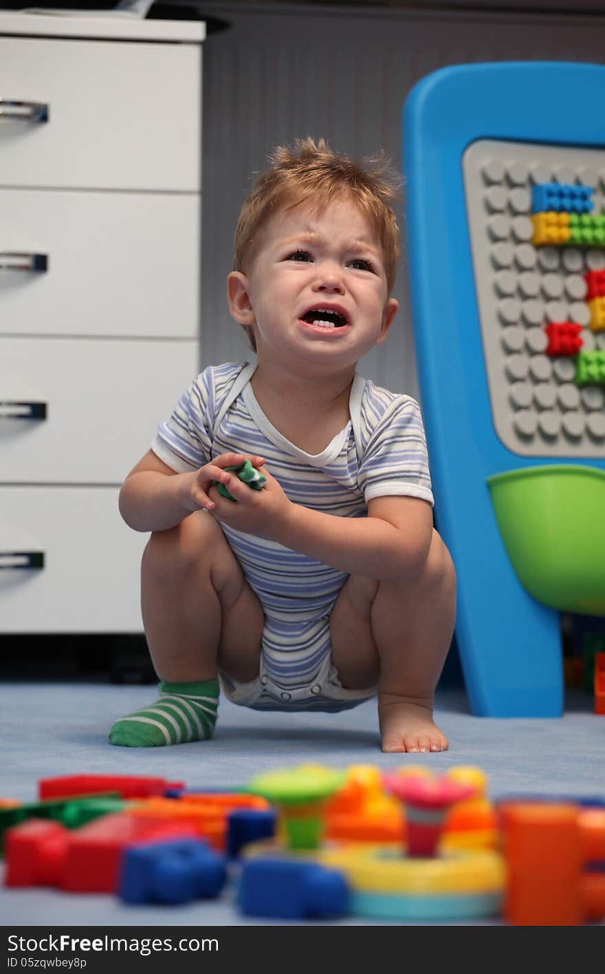 A baby boy crying in children's room