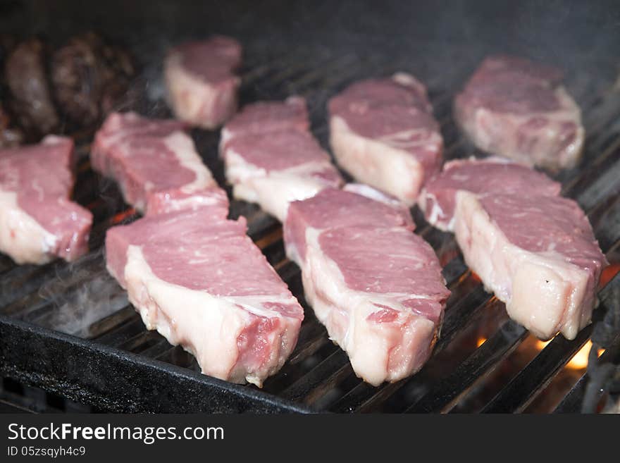 Beef steak raw on an open flame grill