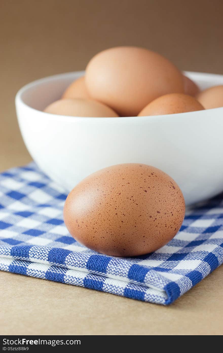 Brown eggs in a white bowl. Overhead view, on Brown