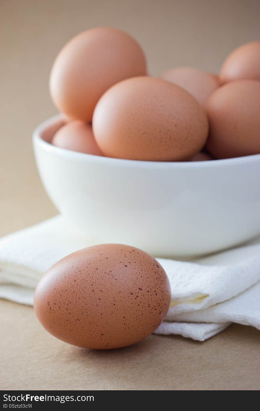 Brown eggs in a white bowl. Overhead view, on Brown