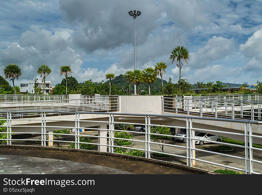 Parking Lot with cloudy blue sky among green environment