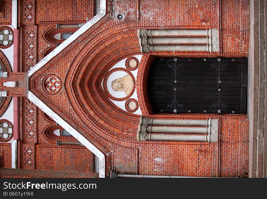 Church door, red wall, wooden big door.