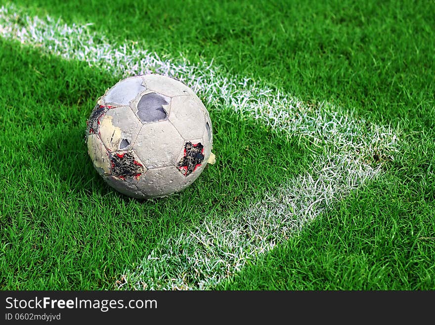 Old soccer ball on soccer field