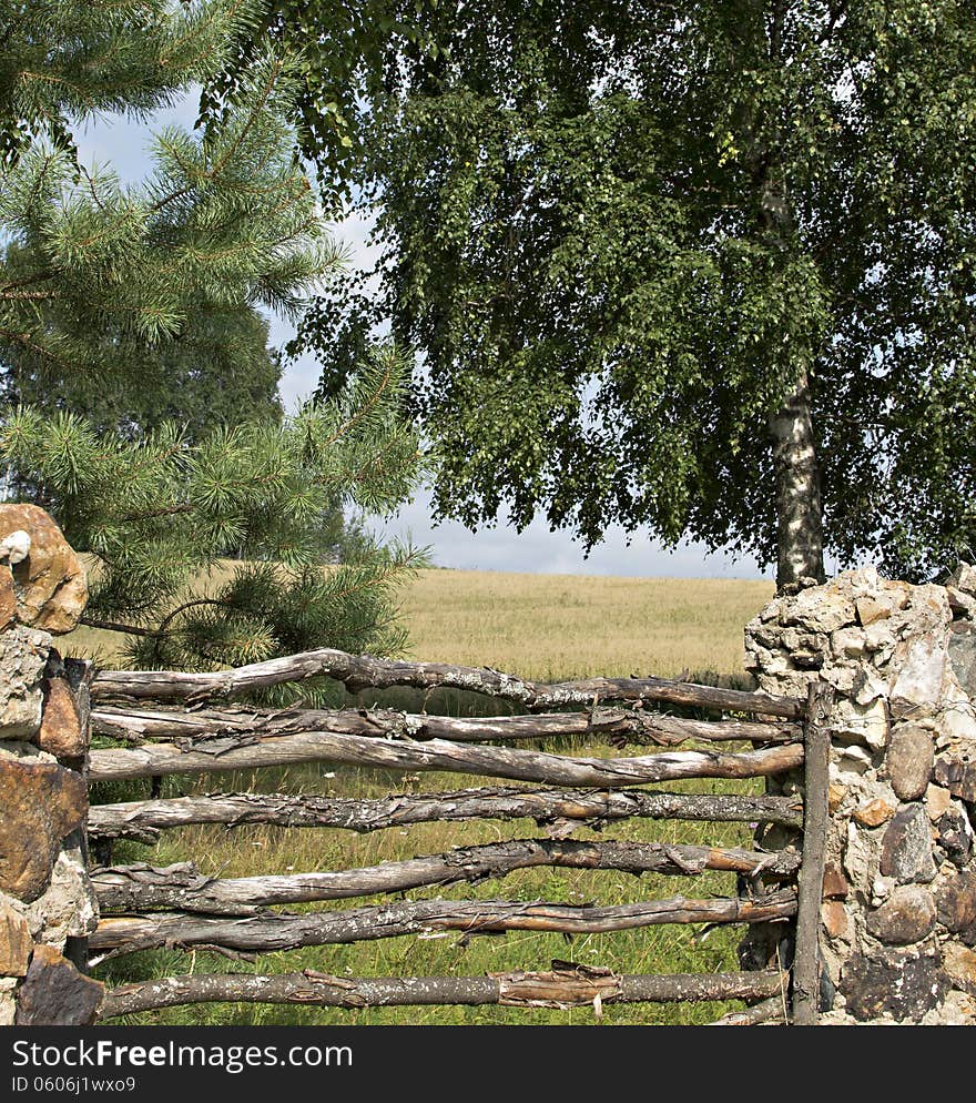 The old fence is made of a stone and a tree. The old fence is made of a stone and a tree.