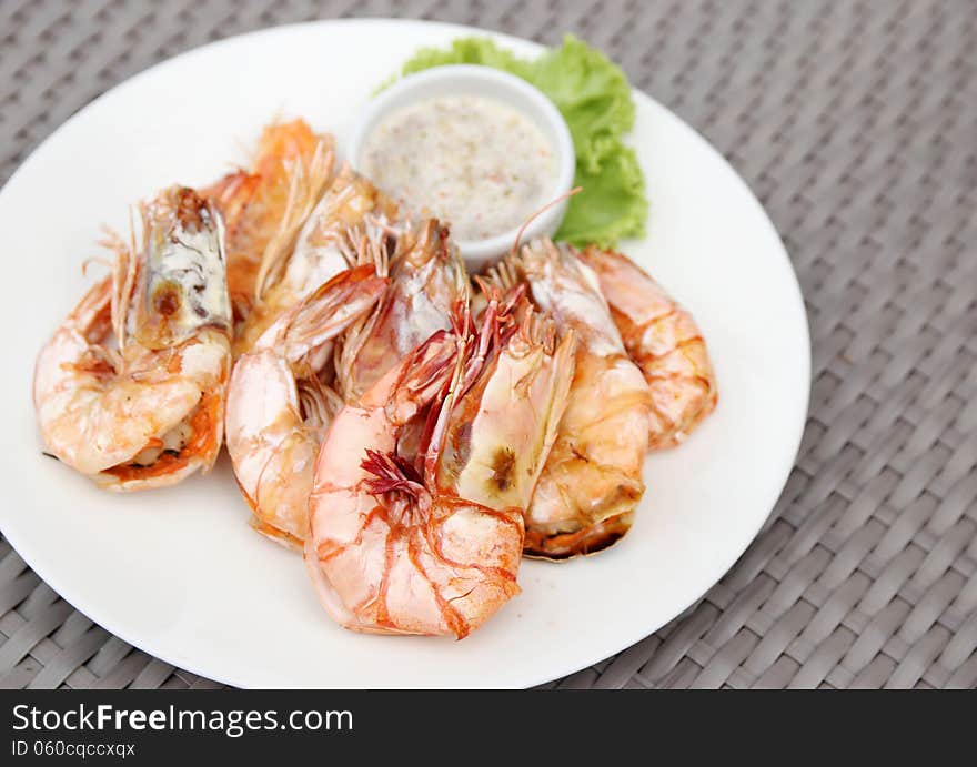 Grilled shrimps with seafood sauce on white plate