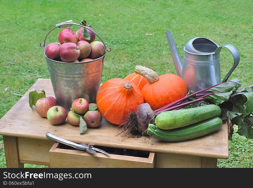 Seasonal vegetables and apples on a wooden table in the garden. Seasonal vegetables and apples on a wooden table in the garden