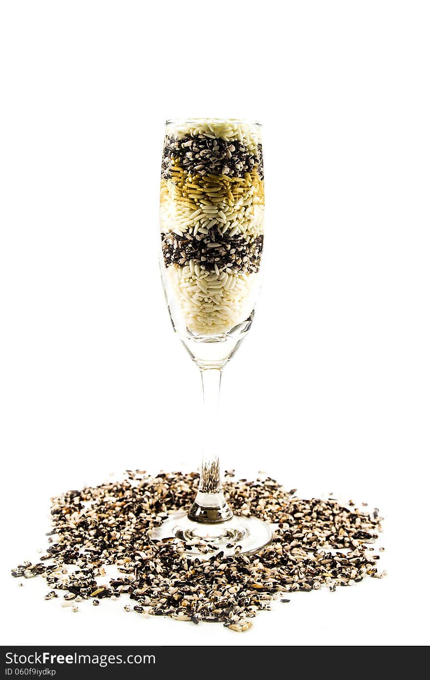 Colored grain in a glass of champagne isolated on white background