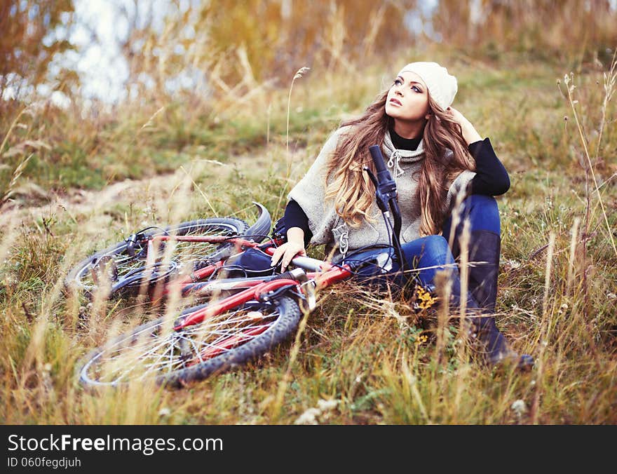 Woman cyclist relaxing in autumn park