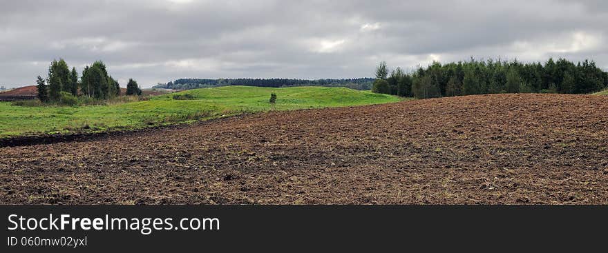 Rural landscape of Lithuania. Plowed field at cloudy day