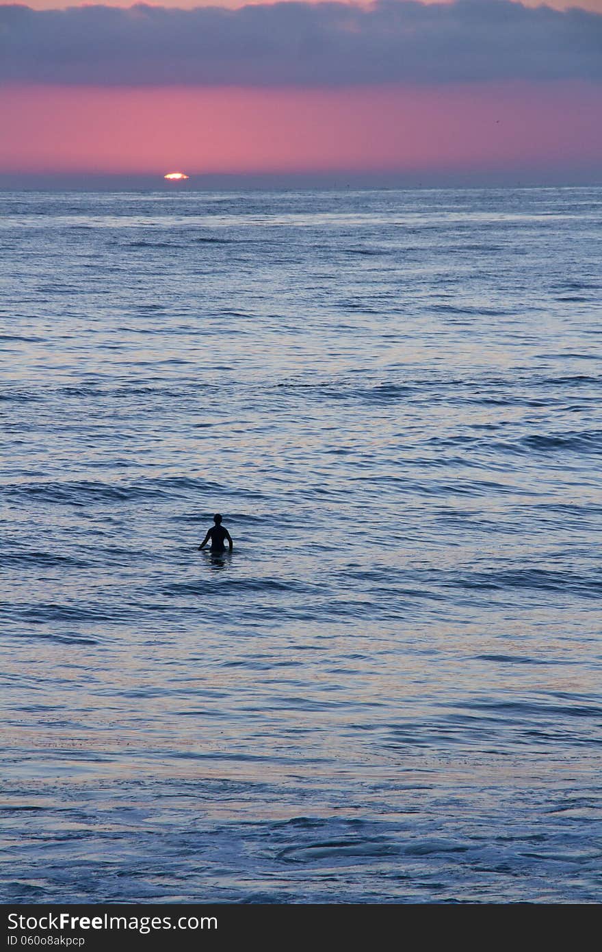 Silhouette of a surfer and paddle-boarder watching the sunset. Silhouette of a surfer and paddle-boarder watching the sunset.