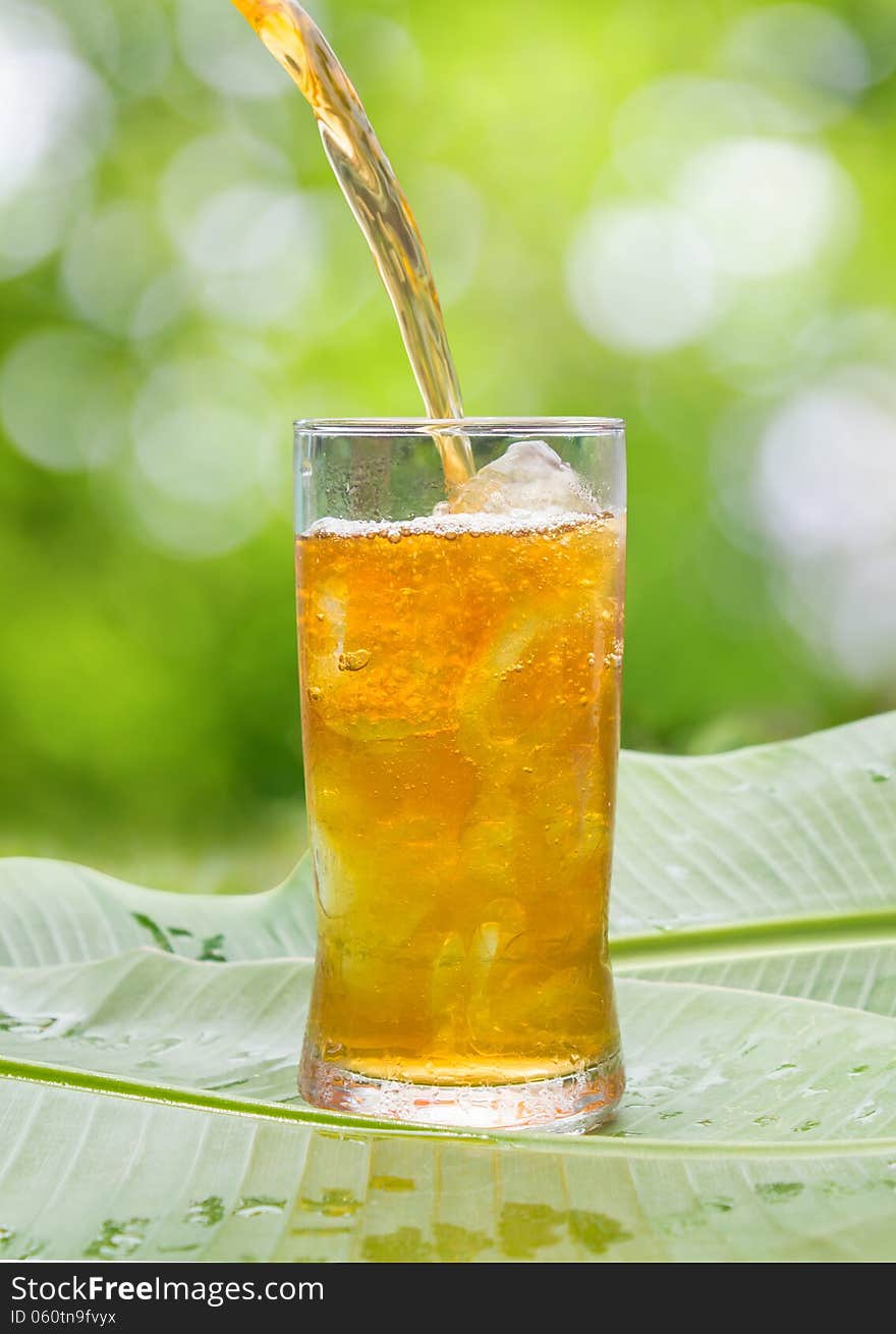 Glass of cold iced tea on Banana leaves ,outdoor.