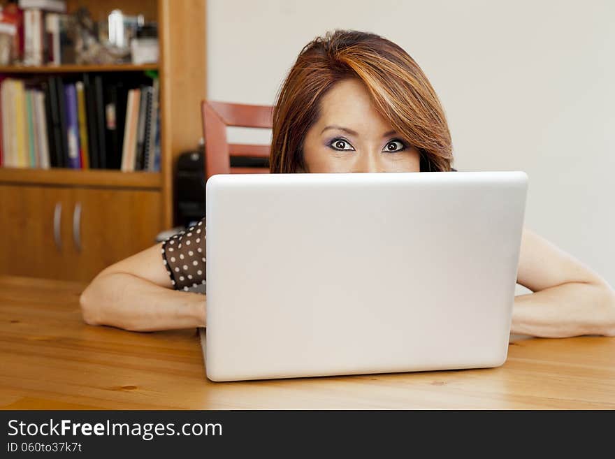 Shy Asian business woman hiding in her office