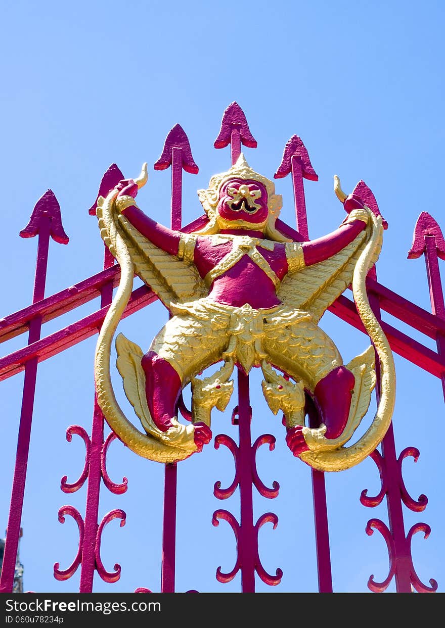 Garuda and Naga on red iron gate.