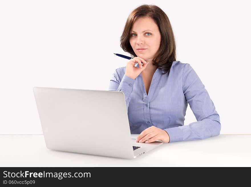 Businesswoman is sitting in front of a modern laptop and looking at the camera, business concept. Businesswoman is sitting in front of a modern laptop and looking at the camera, business concept