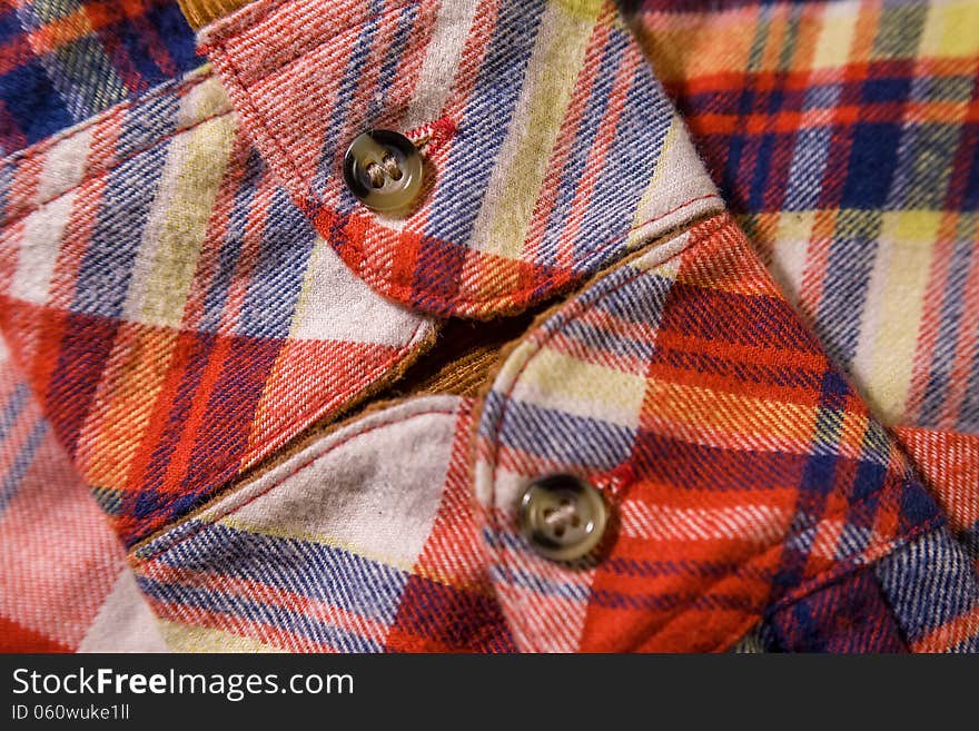 Close up of a checkered shirt cuff with buttons